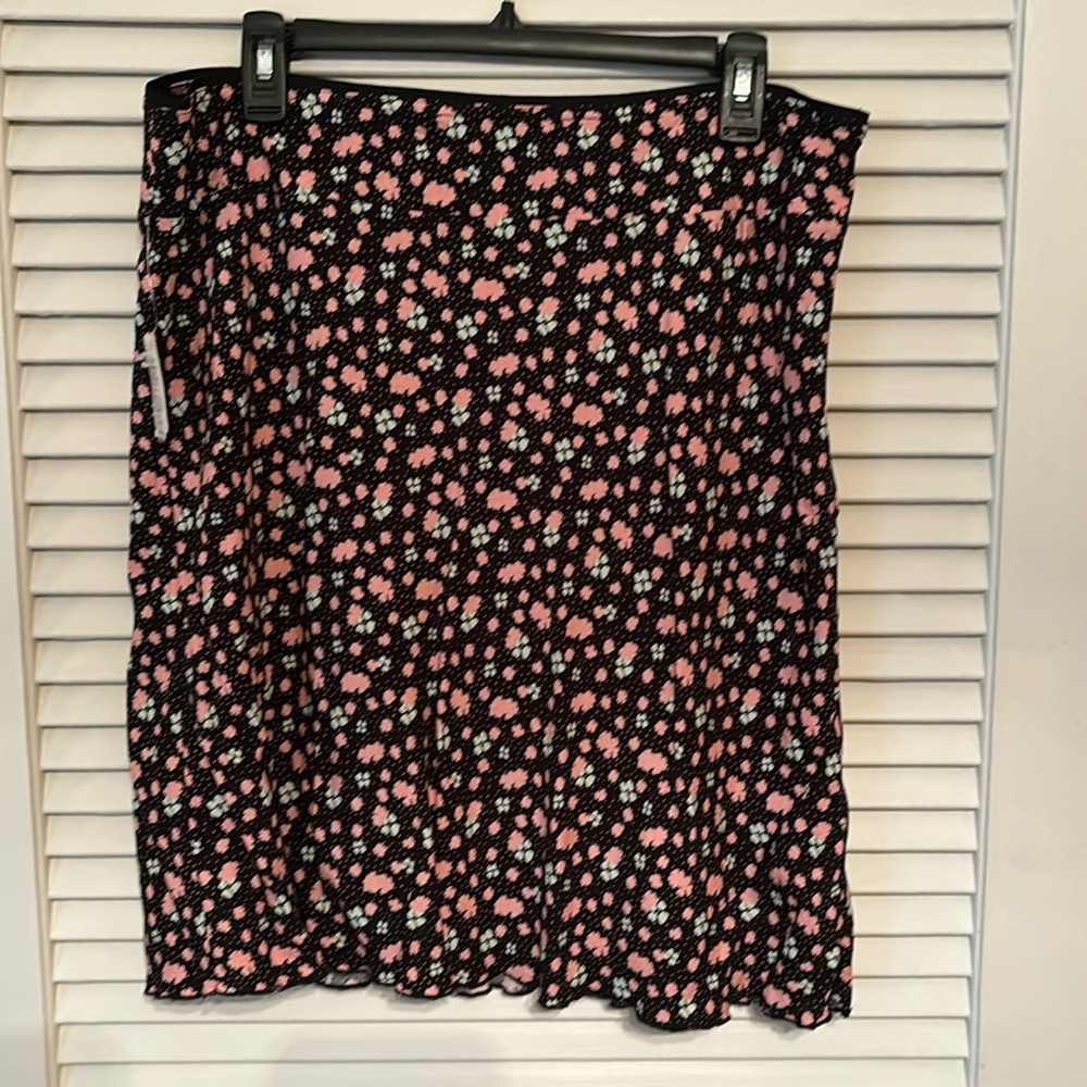 Free People flouncy skirt. Black background with pink and mint green flowers.